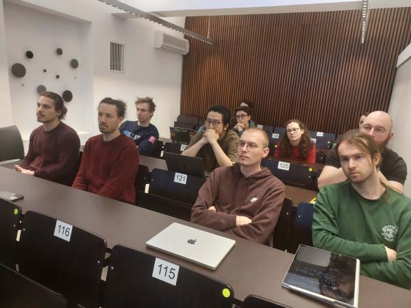 A diverse audience of students, attentively listening to a presentation