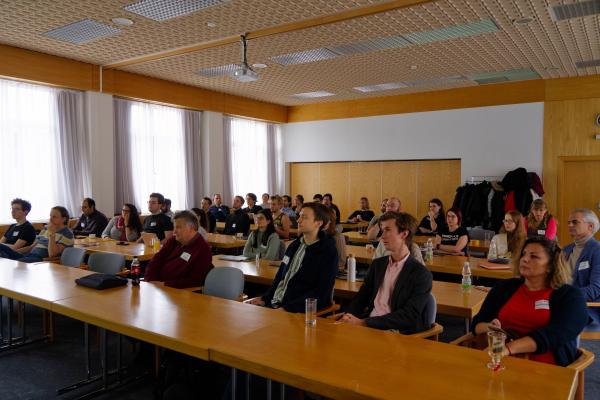 Participants sitting in an auditorium during a retreat, listening attentively to a presentation