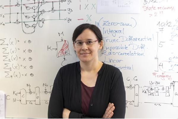 Photo of Maria Eichlseder standing in front of a whiteboard with formulas and schematics